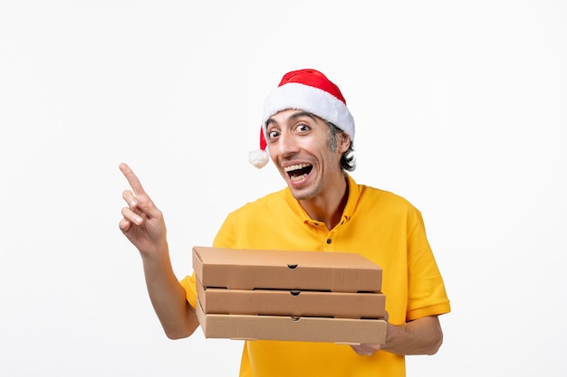 Correio masculino de vista frontal com caixas de pizza na parede branca trabalho de entrega de uniforme de serviço