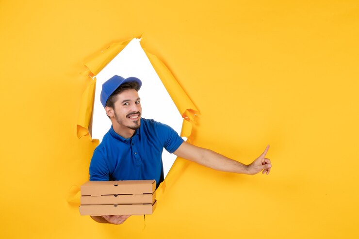 Foto grátis correio masculino de vista frontal segurando caixas de pizza no espaço amarelo