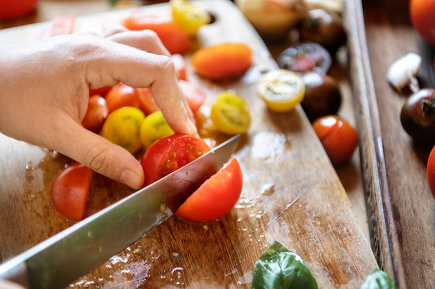 Cortando tomates em uma tábua de cortar