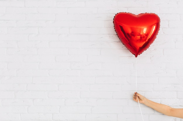 Foto grátis cortar a mão segurando o balão do coração