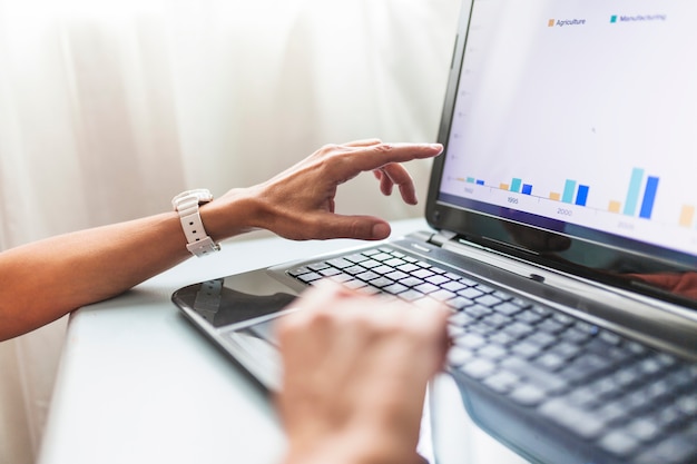 Foto grátis cortar as mãos usando o laptop no escritório