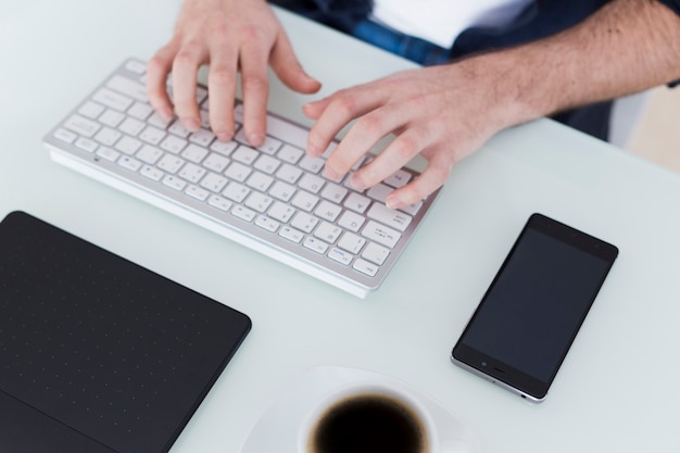 Foto grátis cortar as mãos usando o teclado do computador