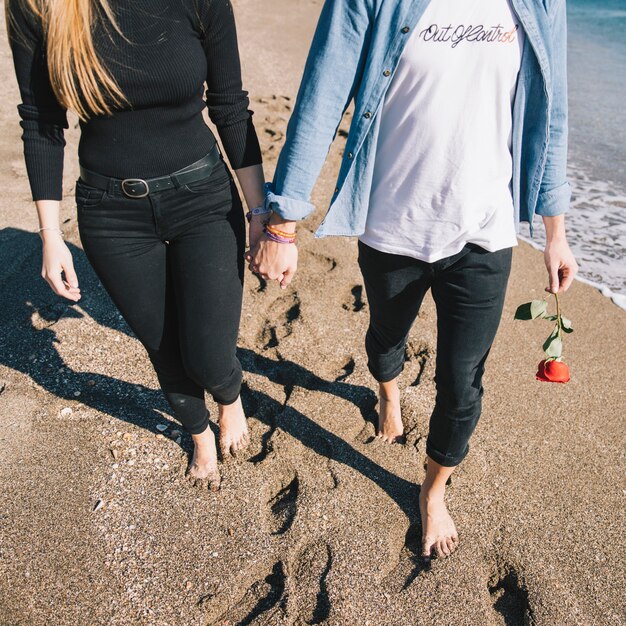 Cortar casal apaixonado caminhando na praia