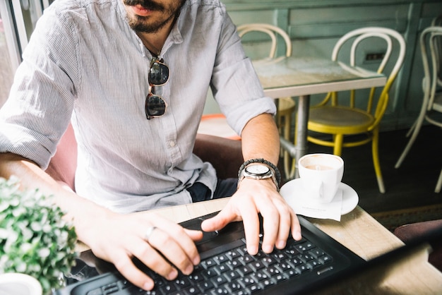 Cortar homem com laptop no café