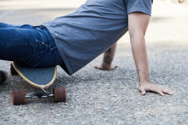 Cortar homem sentado em longboard no pavimento