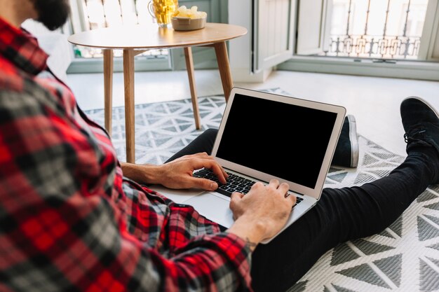 Cortar homem usando o laptop no chão