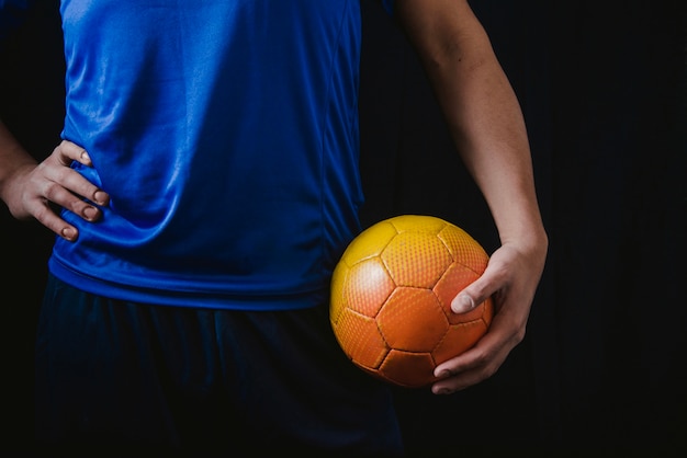 Foto grátis cortar jogador de futebol segurando bola