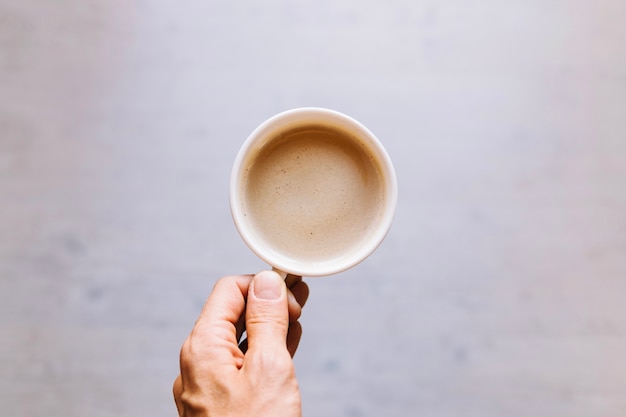 Cortar mão segurando xícara de café