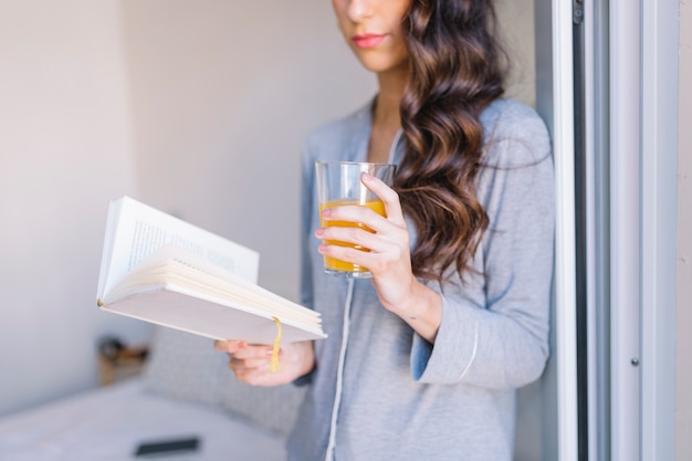 Cortar mulher com livro de leitura de suco