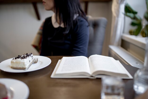 Cortar mulher com livro no café