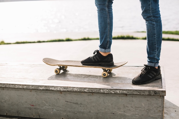 Cortar o adolescente pisando no skate na fronteira