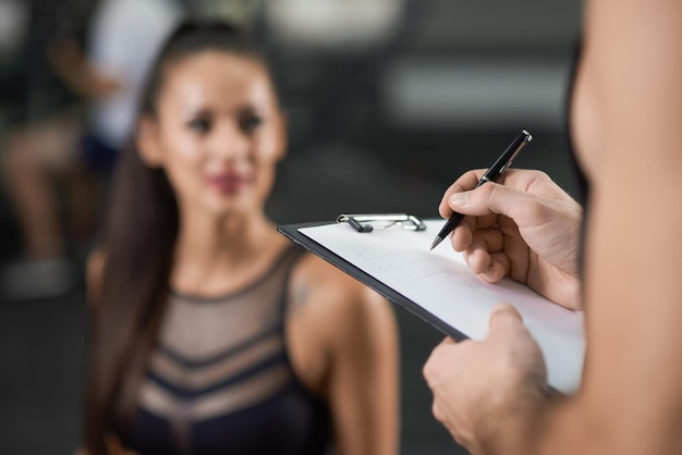 Cortar o retrato de uma mulher se exercitando na academia