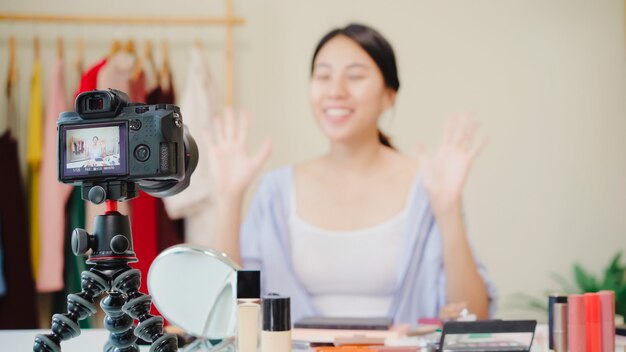 Cosméticos da beleza do presente do blogger da beleza que sentam-se na câmera dianteira para gravar o vídeo.