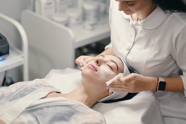 Cosmetologista feminina fazendo tratamento facial para uma bela woma