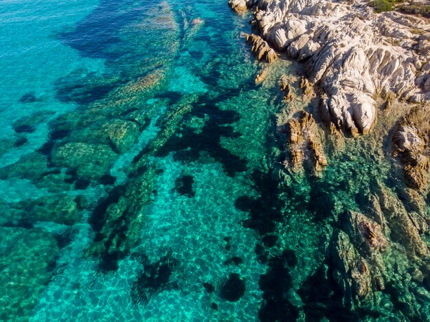 Costa do mar Egeu com rochas perto da costa e sob a água azul transparente, vista do drone, Grécia