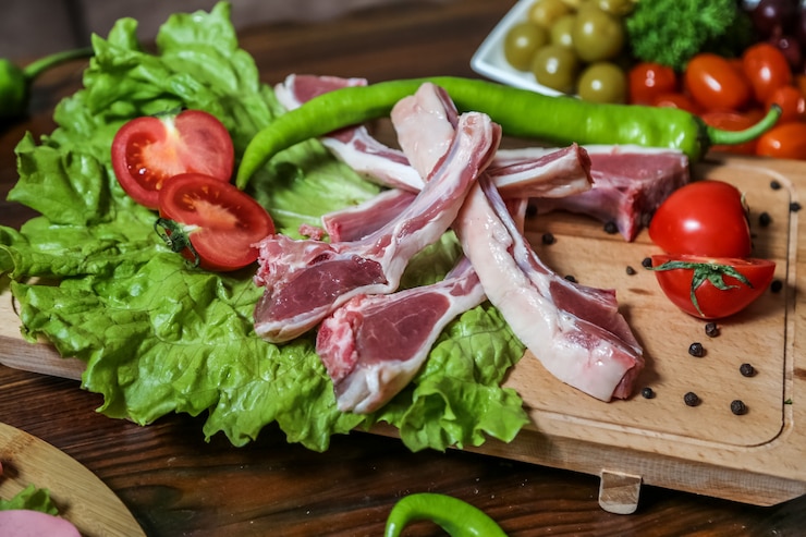 Foto grátis costelas cruas na placa de madeira preparando-se para cozinhar