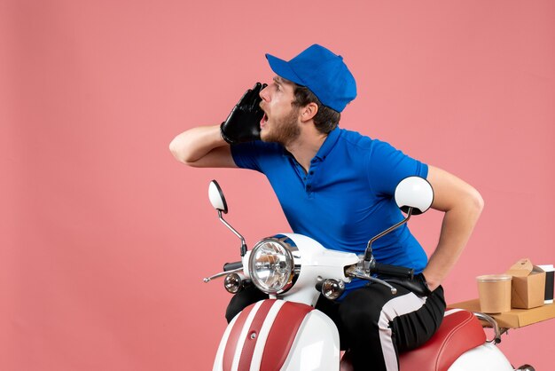 Courier masculino de uniforme azul ligando para alguém em comida rosa, entrega de bicicleta, trabalho de cor, serviço de fast-food