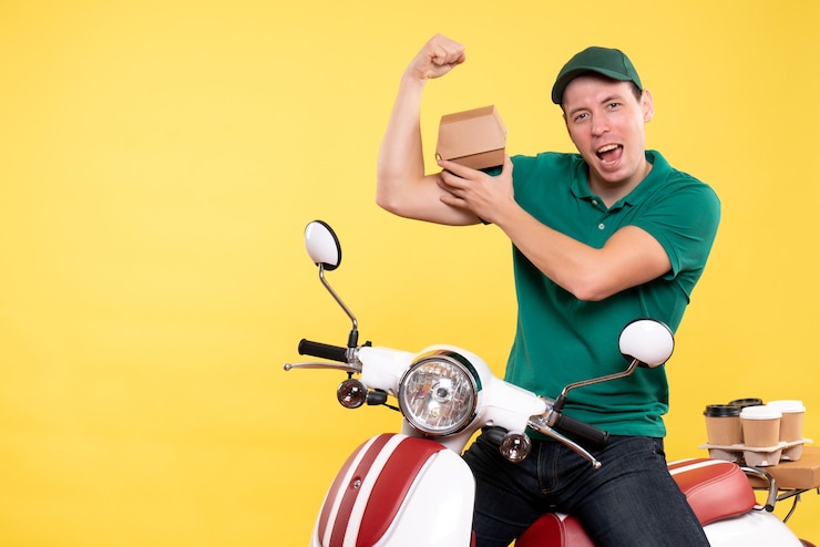 Foto grátis courier masculino de uniforme segurando um pequeno pacote de comida em amarelo