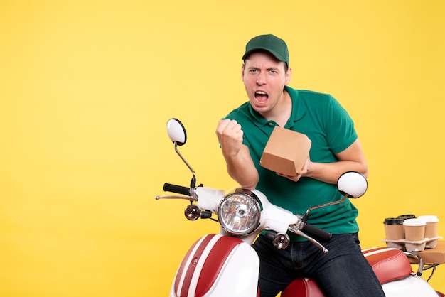 Courier masculino de uniforme segurando um pequeno pacote de comida em amarelo