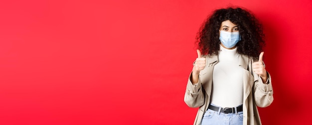 Foto grátis covid distanciamento social e conceito de quarentena alegre mulher elegante vestindo sobretudo e medica