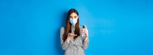Covid distanciamento social e conceito de saúde linda garota com máscara médica usando desinfetante para as mãos h