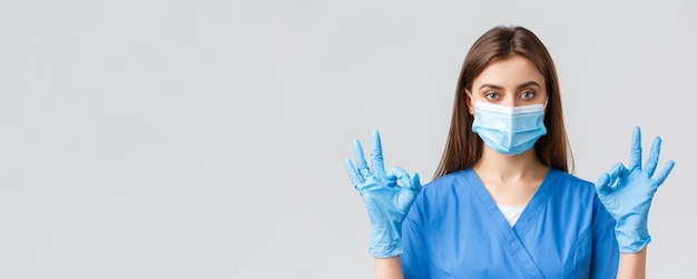 Covid19, prevenindo vírus, profissionais de saúde e conceito de quarentena Enfermeira profissional ou médica na clínica, bata azul e máscara médica mostram sinal bem, tudo sob controle