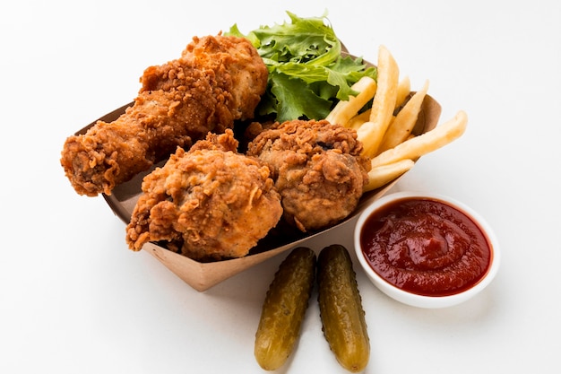 Foto grátis coxinhas de frango frito de ângulo alto com ketchup e batatas fritas