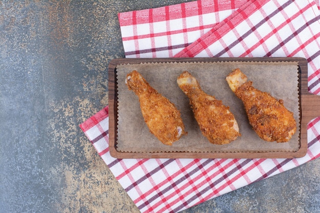 Coxinhas de frango grelhado na placa de madeira com toalha de mesa. Foto de alta qualidade
