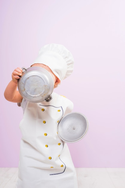 Foto grátis cozinhe a criança cobrindo o rosto com pote