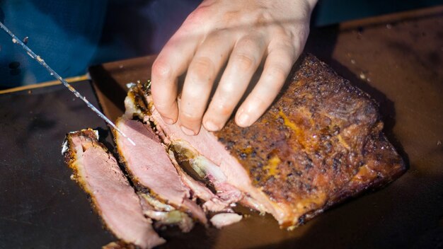 Cozinhe fazendo refeição. Carne de corte, churrasco