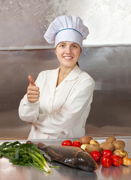 Cozinhe mulher com peixe carpa