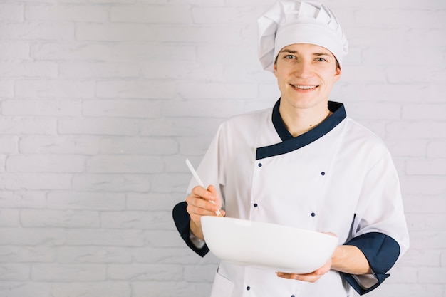 Foto grátis cozinhe segurando a colher com uma tigela grande