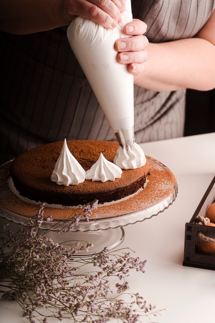 Foto grátis cozinheiro colocando decorações de glacê no bolo