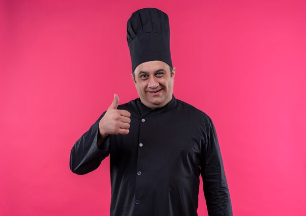 Cozinheiro de meia-idade sorridente com uniforme de chef com o polegar para cima