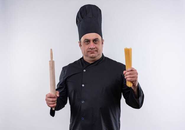 cozinheiro masculino de meia-idade em uniforme de chef segurando o rolo de massa e espaguete na parede branca isolada