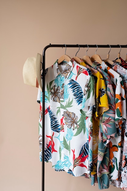 Cremalheira de roupas com camisas florais havaianas em cabides e chapéu