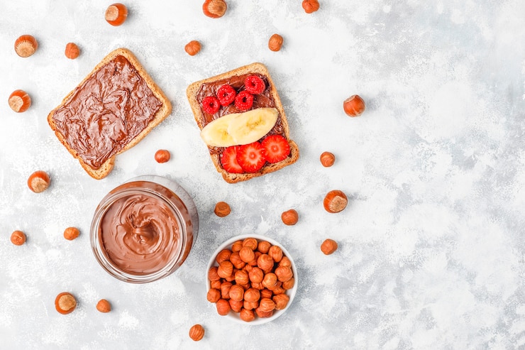 Foto grátis creme de propagação ou nougat de chocolate com avelãs em frasco de vidro no concreto, copyspace