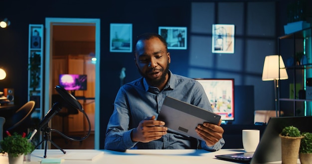 Criador de conteúdo bipoc filmando revisão de tecnologia de tablet recém-lançado desembalando-o e apresentando especificações para o público estrela da internet mostrando dispositivo digital para os espectadores