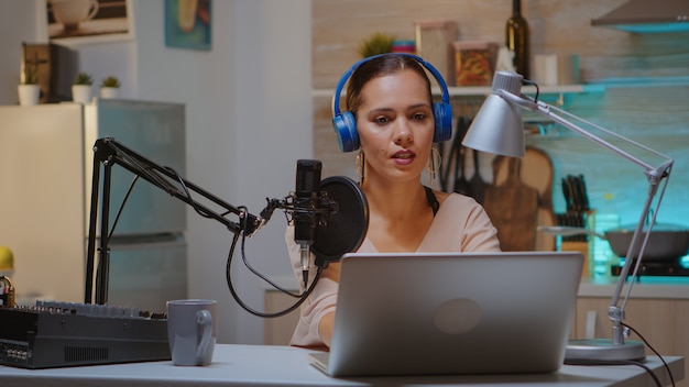 Foto grátis criador de conteúdo usando fones de ouvido enquanto grava um novo episódio para podcast. apresentador de programas criativos on-line produção on-line no ar, apresentador de programas de transmissão pela internet, streaming de conteúdo ao vivo, mídia de gravação