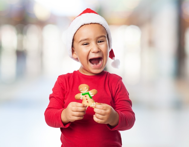 Criança alegre que levanta com um bolinho delicioso