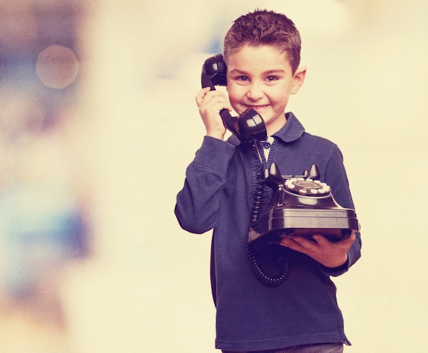 Criança bonito com um telefone do vintage