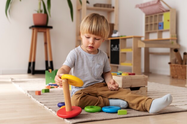 Criança brincando com brinquedos de madeira tiro completo