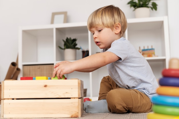 Foto grátis criança brincando com brinquedos de tiro completo