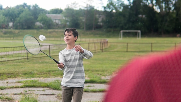 Criança brincando de badminton ao ar livre