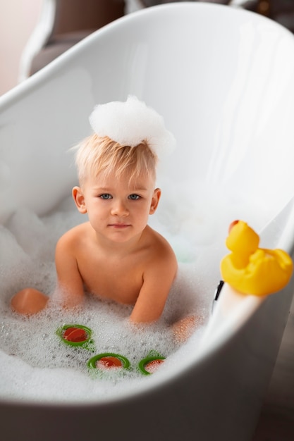 Criança brincando na banheira com brinquedos