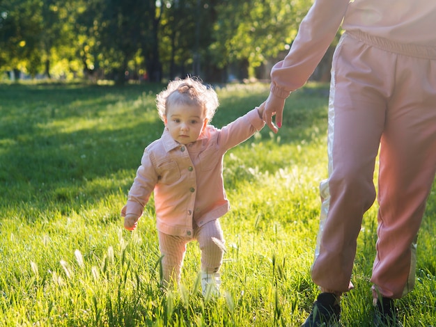 Criança com roupas cor de rosa em pé na grama