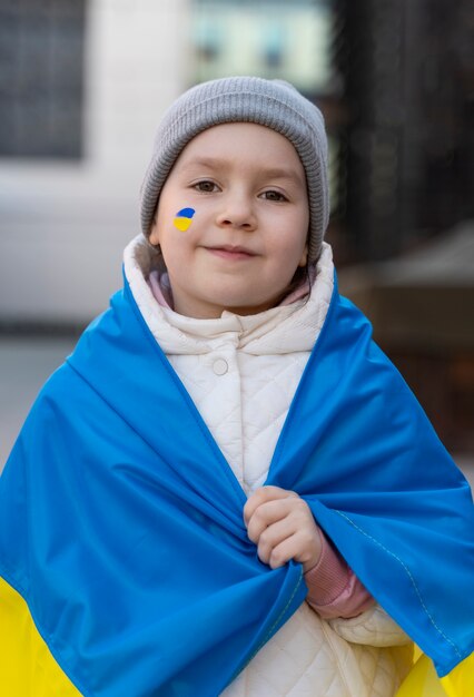 Criança com tiro médio de pintura de bandeira ucraniana