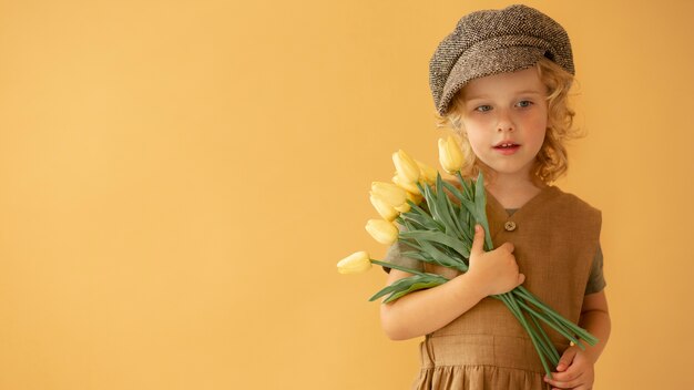 Criança com tiro médio segurando flores