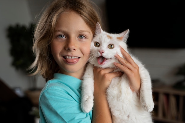 Criança com tiro médio segurando gato