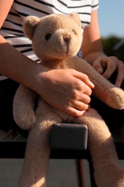 Foto grátis criança com urso de peluche ao ar livre